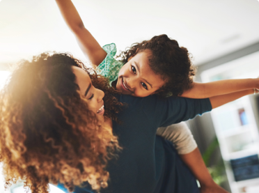 Happy kid getting piggy back ride on mom's back - benefits of term life insurance